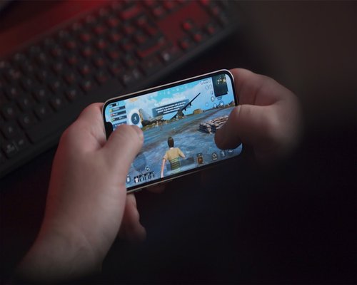 Smartphone with a fictional beginner-friendly game screen displayed during a gaming exhibition